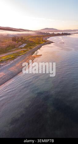 Drohnenfotografie aus der Vogelperspektive des Island View Beach bei Sonnenuntergang, Saanich Peninsula, Victoria BC Kanada. Malerischer Sonnenuntergang über dem Sandstrand in der goldenen Stunde. Stockfoto