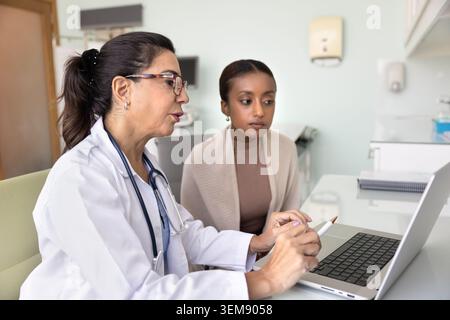 Leitende Ärztin, die junge afrikanische Patientin konsultiert Stockfoto