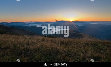 Sonnenaufgang mit Sonnenstrahlen über nebligen Bergtälern von Krizna aus gesehen im Mala Fatra Nationalpark, Slowakei. Stockfoto