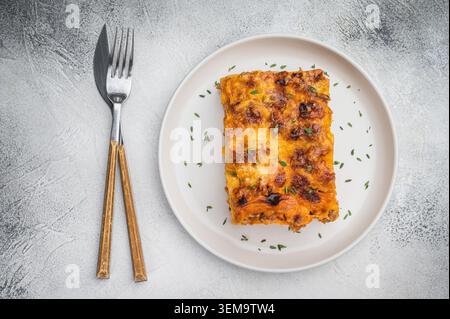 Hausgemachte Lasagne-Scheibe aus Rindfleisch mit reichhaltiger Fleischsoße, Nudelblätter und käsiger Kruste, serviert auf weißem Teller. Stockfoto