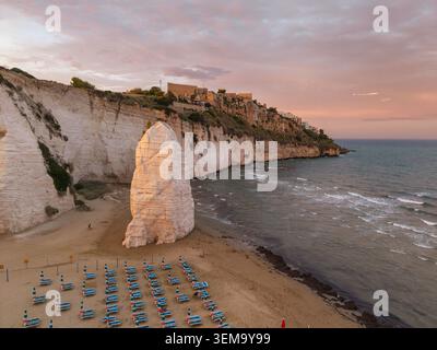 Strand Spiaggia di Castello mit Pizzomunno Klippe und Vieste Altstadt, Italien Stockfoto