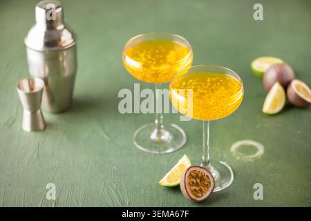 Martini-Cocktail mit Passionsfrucht. Saures alkoholisches Getränk mit frischem Passionsfrucht und Limette, mit Barwerkzeugen. Stockfoto