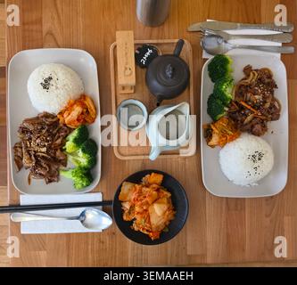 Koreanisches BBQ-Schweinefleisch mit Kimchi-Salat und grünem Oolong-Tee – Genießen Sie zartes koreanisches BBQ-Schweinefleisch, das perfekt gegrillt und mit einem frischen, würzigen Kimchi-Salat serviert wird. Stockfoto
