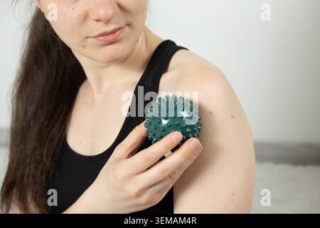 Frau, die Massageball zur Linderung der Schulter benutzt Stockfoto
