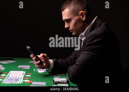 Schreiben Sie Ihre Wette gewinnt auf einem Smartphone auf dem Pokertisch. Wetten, Sportwetten, Buchmacher. Gemischte Medien. Stockfoto