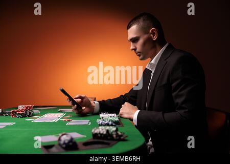 Schreiben Sie Ihre Wette gewinnt auf einem Smartphone auf dem Pokertisch. Wetten, Sportwetten, Buchmacher. Gemischte Medien. Stockfoto