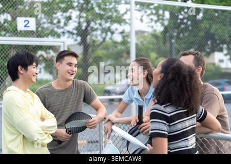 Aktive, vielfältige Leute spielen Pickleball auf dem Outdoor Court Stockfoto