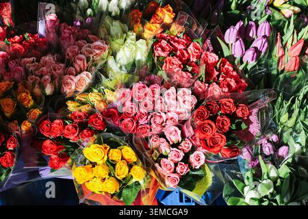 Bunte Blumensträuße werden am Marktstand ausgestellt. Frische Rosen und Frühlingsblumen für Geschenke, Feiern und besondere Anlässe. Stockfoto