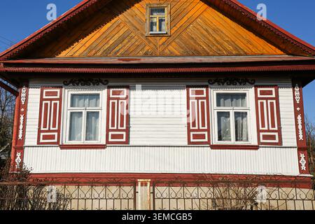 Traditionelle Holzfassade mit dekorativen Fensterrahmen. Regionale Architektur und Kulturerbe im Freien. Stockfoto