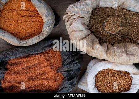 Auswahl an traditionellen usbekischen Gewürzen, getrockneten Kräutern und gemahlenen Gewürzen in offenen Säcken auf einem lokalen Markt in Usbekistan, Zentralasien, von ab betrachtet Stockfoto