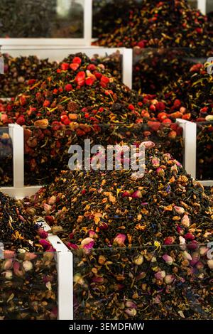 Nahaufnahme einer farbenfrohen Kräutertee-Mischung mit getrockneten Rosenknospen und Beeren, die in Glasbehältern auf einem traditionellen usbekischen Basar gestapelt sind und zentralasiatische spi zeigen Stockfoto