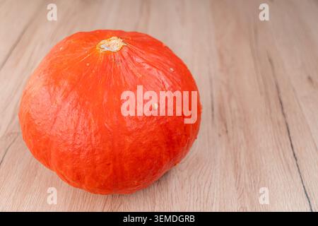 Orangefarbener Kürbis auf natürlicher Holzoberfläche Stockfoto