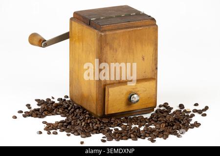 Vintage Kaffeemühle aus Holz mit verstreuten Kaffeebohnen Stockfoto