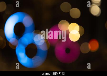 Abstrakter Bokeh-Hintergrund mit blauen und rosafarbenen Neon-Ringlichtern Stockfoto