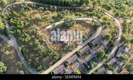 Aus der Vogelperspektive eines verlassenen Dorfes oder Resorts mit leeren Gebäuden und gewundenen Straßen, umgeben von trockener Vegetation und Olivenbäumen in Andalusien Stockfoto