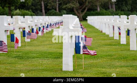 Französische und amerikanische Flaggen markieren jeden Grabstein auf dem amerikanischen Friedhof der Normandie nach einer Massenwiederaufnahme von US-Soldaten während eines D-Day 82 c Stockfoto