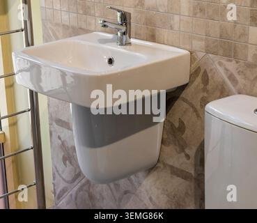 Kompaktes halbes Standbecken mit Edelstahlmischer Stockfoto