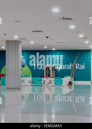 Bali, Indonesien: Hell beleuchteter Indoor-Spielbereich für Kinder. Pastellfarben dominieren den fröhlichen Raum. Große Wand zeigt Details zum Flughafen an. Stockfoto