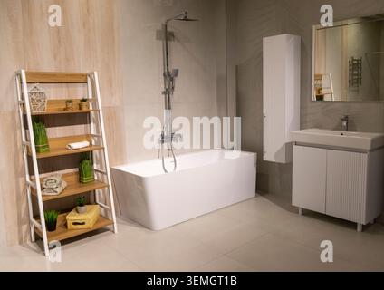 Modernes Badezimmer mit freistehender Badewanne und Holzleiterregal Stockfoto