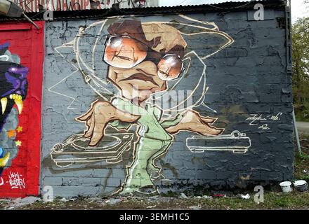 Stockholm, Schweden, 17. Mai 2026. Lebendiges Graffiti-Fototapete einer DJ-Cartoon-Figur mit Sonnenbrille, die sich auf Plattenspieler vermischt, die auf strukturiertem Beton gemalt sind Stockfoto