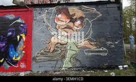 Stockholm, Schweden, 17. Mai 2026. Lebendiges Graffiti-Fototapete einer DJ-Cartoon-Figur mit Sonnenbrille, die sich auf Plattenspieler vermischt, die auf strukturiertem Beton gemalt sind Stockfoto