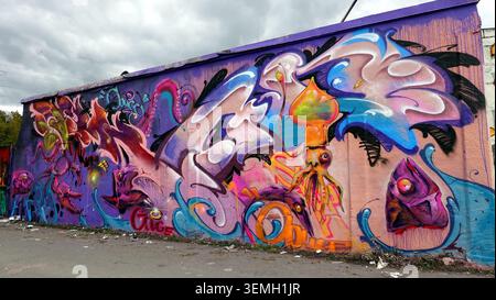 Stockholm, Schweden, 17. Mai 2026. Ein lebendiges Graffiti-Wandbild mit Neonkalmar, stilisierten Fischen und wirbelnden abstrakten Formen, die auf einem gemalt sind Stockfoto