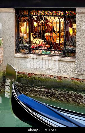 Eine Gondel gleitet durch die Werkstatt einer traditionellen venezianischen Maskierin in ihrer Werkstatt. Seit Jahrhunderten stellen Handwerker die begehrten Masken her. Stockfoto