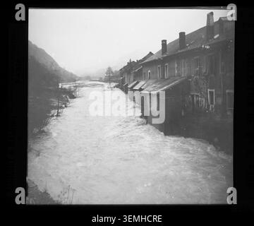 Häuser in Chèzery stehen neben aufsteigenden Überschwemmungen während der Überschwemmung im Januar 1910 in Ain, wo die geschwollene Valserine Gebäude und umliegende Flächen in der Nähe des Dorfes bedroht. Stockfoto