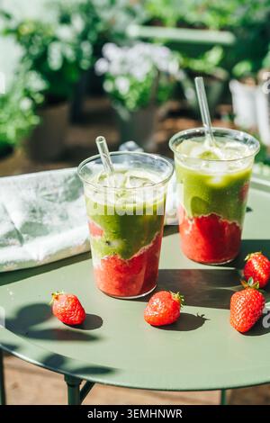 Erdbeere Matcha Latte Drinks auf sonnigem Balkon Stockfoto