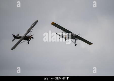 Zwei deutsche Fieseler Storch-Beobachtungsflugzeuge aus dem Zweiten Weltkrieg im Formationsflug auf der Duxford Airshow, Juni 2026 Stockfoto