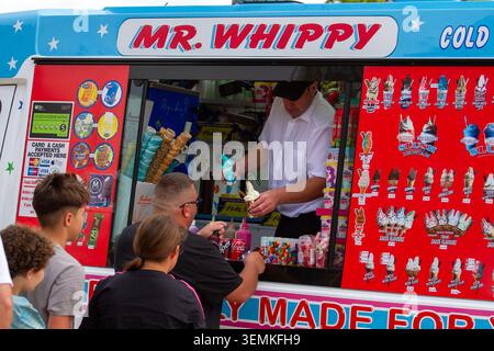 Mr Whippy bedient Kunden mit dem berühmten 99'-Eis am heißen Sommertag. Southport, UK. Stockfoto