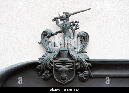 Altes polnisches Wappen mit gekröntem Löwen mit Schwert und Stierkopf an der Mauer in Polen Stockfoto