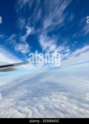 Blick auf wunderschöne Wolken oben und Wolken unten, reisen in einem Flugzeug Stockfoto