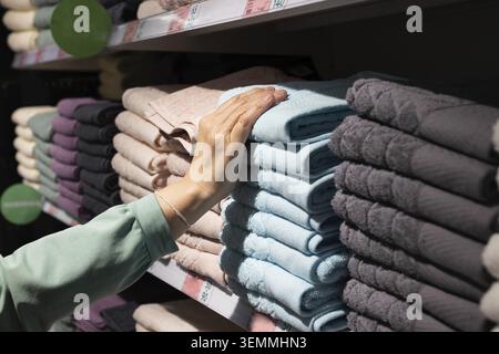 Mehrfarbiger Stapel Handtücher auf einem Stapel in Supermarktregalen. Einkaufen für die ganze Familie Stockfoto