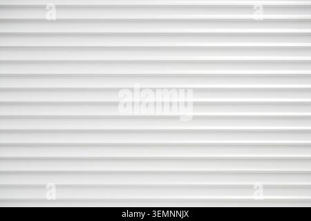Textur von weißen Kunststoff-Lamellen mit horizontalen Lamellen in perfekter Parallelausrichtung. Stockfoto