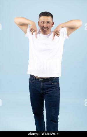 Entspannter junger Mann, der mit den Händen hinter dem Kopf nach unten blickt Stockfoto
