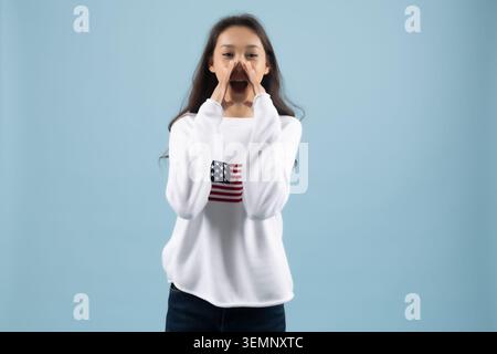 Ausdrucksstarke junge Frau, die laut schreiend die Hände in der Nähe ihres Mundes hält Stockfoto