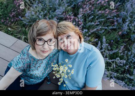 Porträt von Mutter und Seniorin mit Daisies im Urban Garden Stockfoto