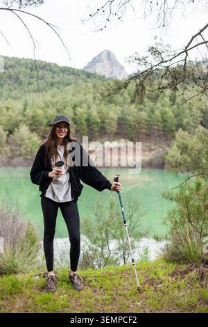 Die junge Frau macht eine Kaffeepause während der Wanderung Stockfoto