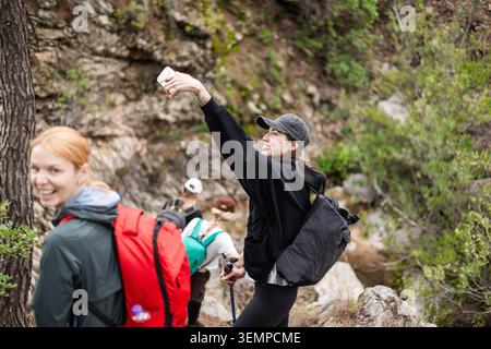 Eine junge Frau, die mit ihren Freunden ein WanderSelfie macht Stockfoto