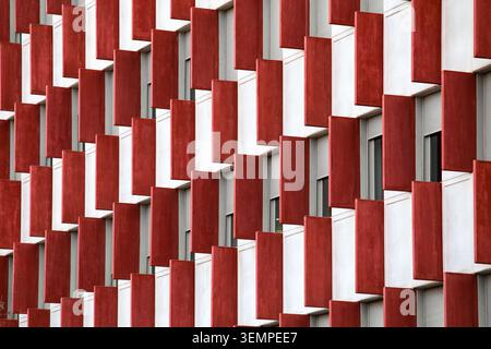 Abstrakte geometrische Fassade mit sich wiederholenden roten Architekturpaneelen Stockfoto