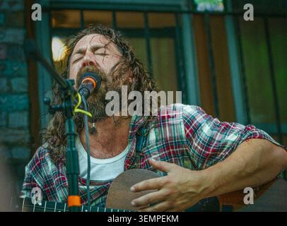 Leidenschaftlicher bärtiger Musiker, der Gitarre singt und spielt Stockfoto