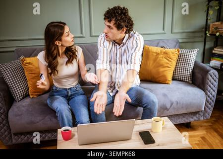 Ein Paar bewertet Produkte und Preise online und diskutiert ihre Auswahl, bevor er einen Kauf abschließt. Stockfoto