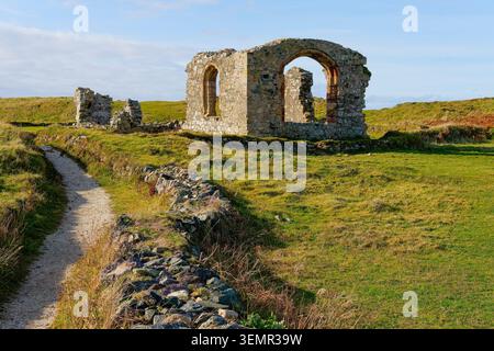 Die Ruinen der St. Dwynwen's Church auf Llanddwyn Island, Anglesey, in der Herbstsonne. Stockfoto