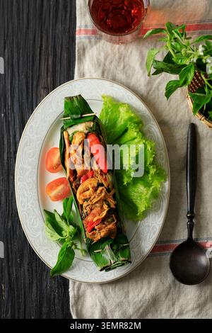 Nasi Bakar Ayam Suwir mit Kemangi, gedämpftem Reis mit gebratenem, würzigem Hähnchen und süßem Basilikumblatt, Umhang mit Bananenblatt und gegrilltem. Top Vie Stockfoto