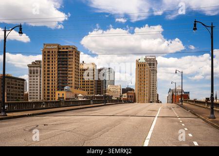 Fußgängerbrücke über den Eisenbahnkorridor mit der Skyline der Innenstadt von Birmingham im Hintergrund in Birmingham, Alabama. Stockfoto