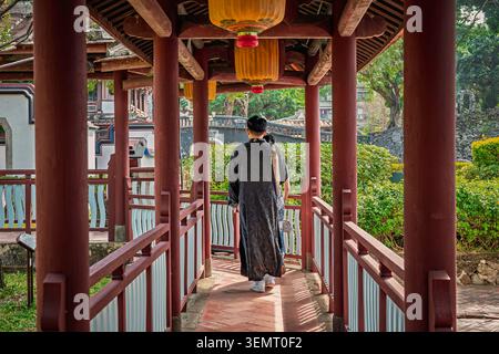 Paare in traditioneller Kleidung gehen durch einen überdachten Korridor im Lin Family Mansion and Garden, Banqiao, Taiwan Stockfoto