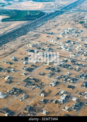 Aus der Vogelperspektive von Dubais weitläufigen Wohnvierteln lassen sich dichte flache Wohnsiedlungen erkennen, die sich über die Wüstenlandschaft erstrecken. Stockfoto