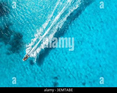 Drohnenblick auf das schwimmende Schnellboot im blauen Meer an sonnigen Tagen Stockfoto