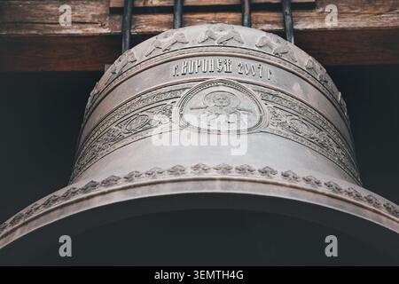 14. April 2026, Lesje, Serbien: Kunstvolle Bronzeglocke mit komplizierten religiösen Ikonographien und Mustern, die in einem Kirchturm der Kathedrale hängt Stockfoto